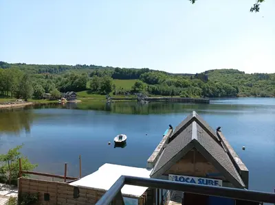 a view of a lake with a boat in it at Gîte mas Jourdane en Haut Languedoc in Anglès