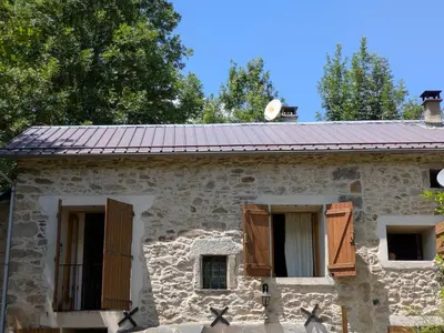 an old stone house with wooden shuttered windows at Gîte mas Jourdane en Haut Languedoc in Anglès