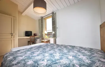 a bedroom with a bed with a blue and white bedspread at 2 Bedroom Gorgeous Home In St-Laurent-De-La-Cabr in Saint-Laurent-de-la-Cabrerisse