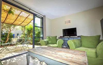 a living room with green chairs and a table at 2 Bedroom Gorgeous Home In St-Laurent-De-La-Cabr in Saint-Laurent-de-la-Cabrerisse