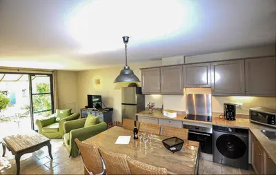a kitchen with a table and a living room at 2 Bedroom Gorgeous Home In St-Laurent-De-La-Cabr in Saint-Laurent-de-la-Cabrerisse