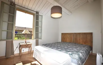 a bedroom with a bed and a window and a lamp at 2 Bedroom Gorgeous Home In St-Laurent-De-La-Cabr in Saint-Laurent-de-la-Cabrerisse