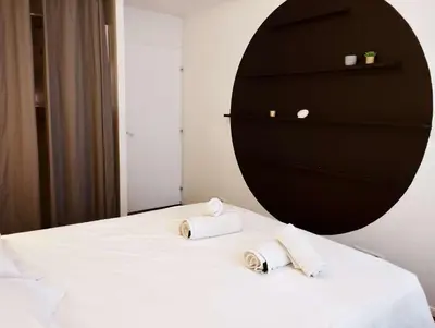 a bedroom with two towels on a bed with a dresser at Very Chic Townhouse with Pool and Garage in Carcassonne
