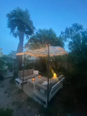 a patio with a table and a tree with lights at Domaine du BaRon in Alzonne