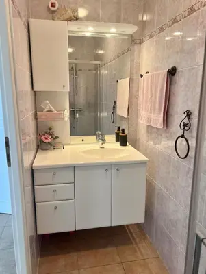 a bathroom with a white sink and a shower at Suite Bleuet in Peyriac-de-Mer