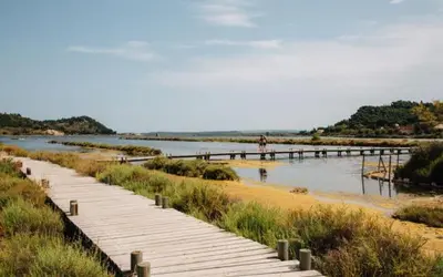 a wooden walkway over a river with a pier at Suite Bleuet in Peyriac-de-Mer