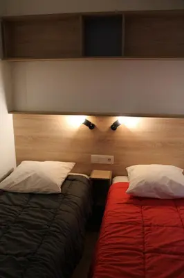 a hotel room with two beds and a head board at Oasis bora bora 4 personnes in Pamiers