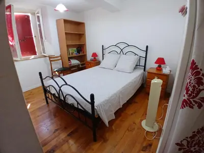 a bedroom with a black bed with white pillows at Charmante maison de village in La Digne-dʼAmont