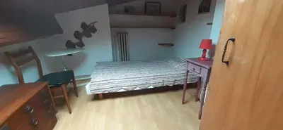 a small bedroom with a bed and a table and chair at Charmante maison de village in La Digne-dʼAmont