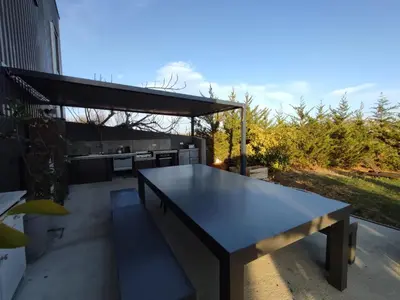 a table on a patio with a kitchen in the background at Logement entre mer et vignes in Fitou