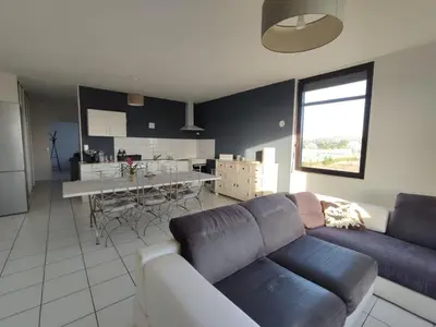 a living room with a couch and a kitchen at Logement entre mer et vignes in Fitou