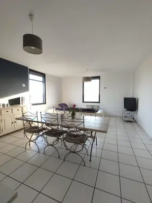 a room with a table and chairs and a tv at Logement entre mer et vignes in Fitou