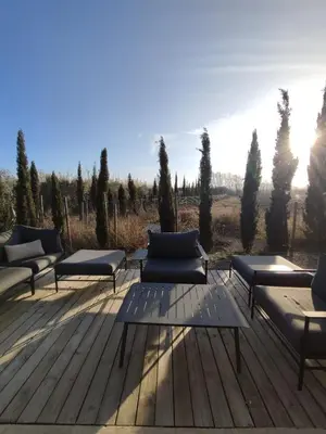 a group of chairs and tables on a wooden deck at Logement entre mer et vignes in Fitou