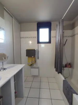 a white bathroom with a shower and a sink at Logement entre mer et vignes in Fitou