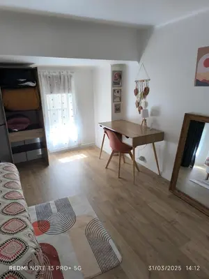 a living room with a wooden table and a desk at Bel Appartement Terracotta au cœur de Narbonne in Narbonne