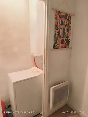 a small refrigerator in a kitchen with a microwave at Bel Appartement Terracotta au cœur de Narbonne in Narbonne