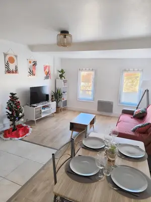 a living room with a table and a couch at Bel Appartement Terracotta au cœur de Narbonne in Narbonne