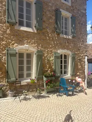 a man sitting in a chair in front of a building at La Retraite in Assignan