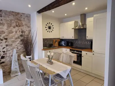 a kitchen with a table and chairs in a room at La Retraite in Assignan