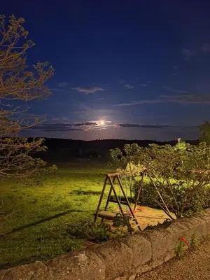 a view of a field at night with the moon at La Retraite in Assignan