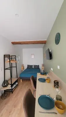 a room with a bed and a table with plates on it at Studio au cœur de Castelnaudary in Castelnaudary