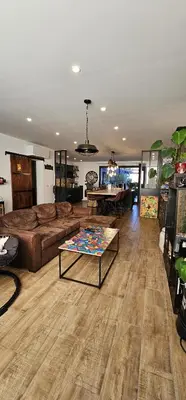 a living room with a couch and a table at Charmante maison industriel au coeur du village in Vinassan