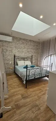 a bedroom with a bed and a brick wall at Charmante maison industriel au coeur du village in Vinassan