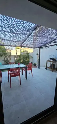 a patio with a table and chairs under a roof at Charmante maison industriel au coeur du village in Vinassan