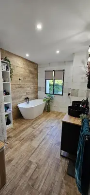 a large bathroom with a white tub and wooden floors at Charmante maison industriel au coeur du village in Vinassan
