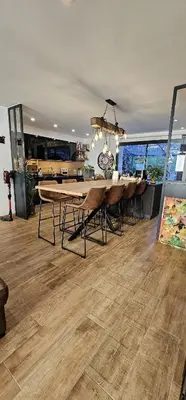 a dining room with a table and chairs on a wooden floor at Charmante maison industriel au coeur du village in Vinassan