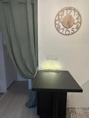 a clock and a table in a room with a curtain at La Maison de Valerie Feng Shui in La Livinière