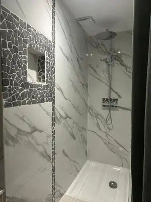 a bathroom with a shower with marble walls at La Maison de Valerie Feng Shui in La Livinière
