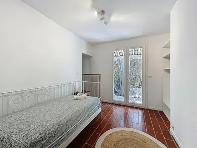 a bedroom with a bed and a large window at L'Oustal Maison de caractere avec Wifi et climatisation in Villedaigne