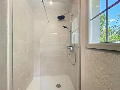 a bathroom with a shower with a glass door at L'Oustal Maison de caractere avec Wifi et climatisation in Villedaigne