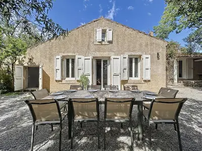 a table and chairs in front of a house at L'Oustal Maison de caractere avec Wifi et climatisation in Villedaigne