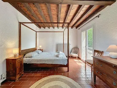 a bedroom with a canopy bed and a wooden ceiling at L'Oustal Maison de caractere avec Wifi et climatisation in Villedaigne