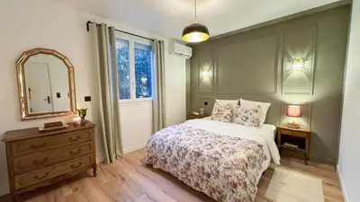 a bedroom with a bed and a mirror and a dresser at Maison Climatisée 5min Cité Terrasse et Parking AK in Carcassonne