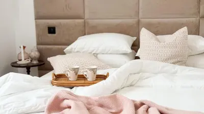 a bed with a tray with three tea cups on it at Maison Climatisée 5min Cité Terrasse et Parking AK in Carcassonne