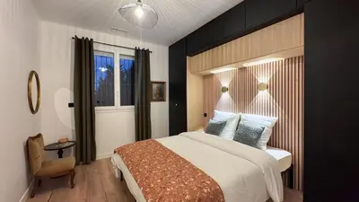 a bedroom with a large bed and a window at Maison Climatisée 5min Cité Terrasse et Parking AK in Carcassonne