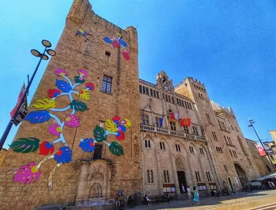 a large stone building with colorful decorations on it at Elegant 2 bedrooms flat - 8mn walk from trainstation in Narbonne