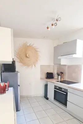 a kitchen with white cabinets and a refrigerator at Elegant 2 bedrooms flat - 8mn walk from trainstation in Narbonne