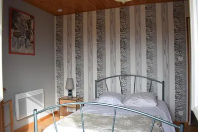 a bedroom with a bed and a wall with stripes at Jolie maison avec piscine in Sigean