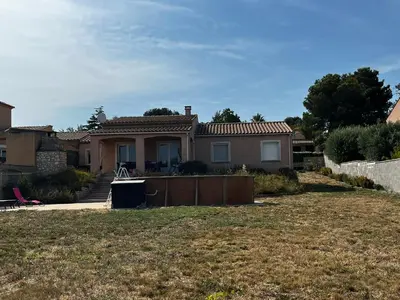a house with a fence in front of a yard at Jolie maison avec piscine in Sigean