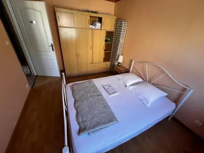 a small bedroom with a bed with white sheets at Jolie maison avec piscine in Sigean