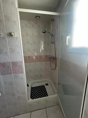 a bathroom with a shower with a black and white drain at Jolie maison avec piscine in Sigean