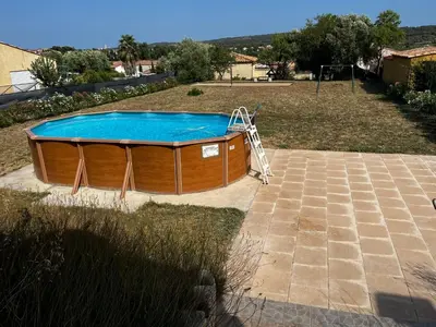 a hot tub with a slide in a yard at Jolie maison avec piscine in Sigean