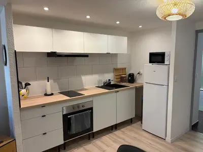 a kitchen with white cabinets and a white refrigerator at Apartamento carccassone in Carcassonne