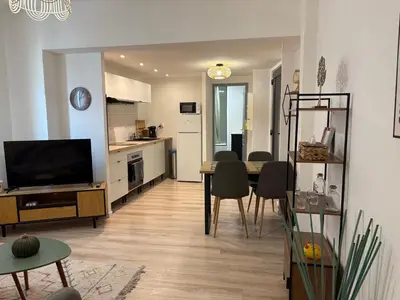 a living room with a dining table and a kitchen at Apartamento carccassone in Carcassonne