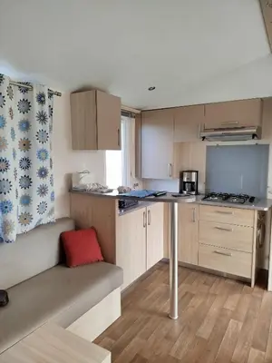 a small kitchen with a couch and a table at Mobil home dans camping 3 étoiles in Saint-Papoul