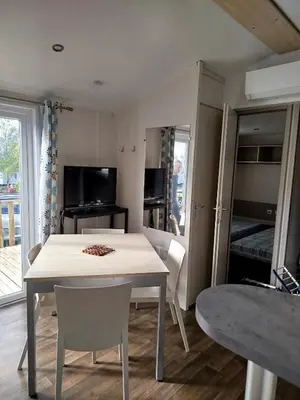 a kitchen and dining room with a table and chairs at Mobil home dans camping 3 étoiles in Saint-Papoul